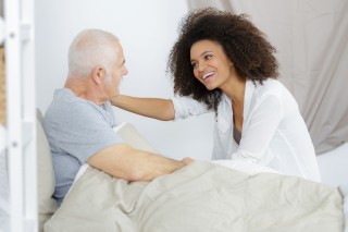 Male patient in bed with doctor by side