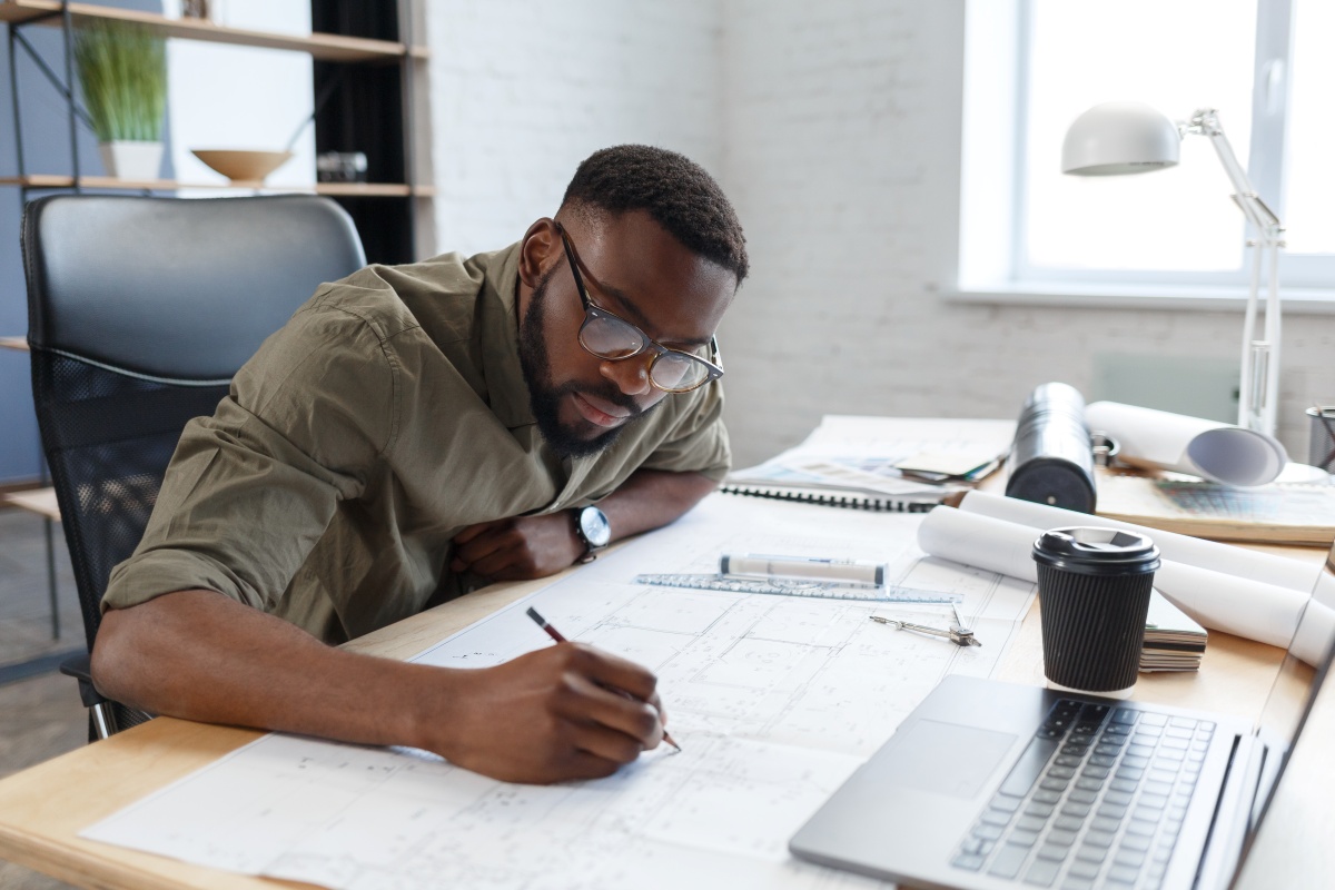 Consultant working on a blueprint at his desk